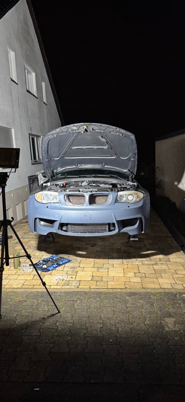 BMW 1er mit geöffneter Motorhaube bei einem Fotoshooting am Tag